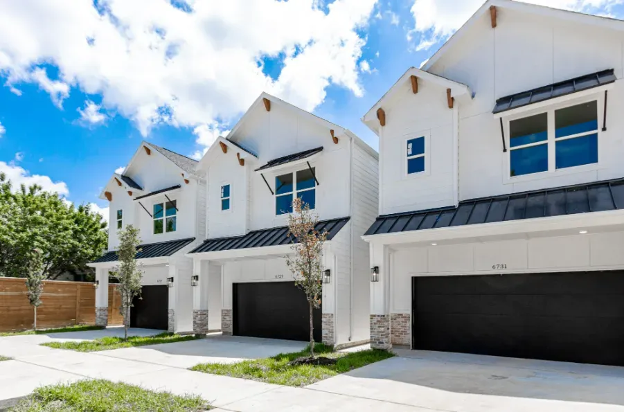 White townhomes with black-trimmed roofs at Del Rio Park