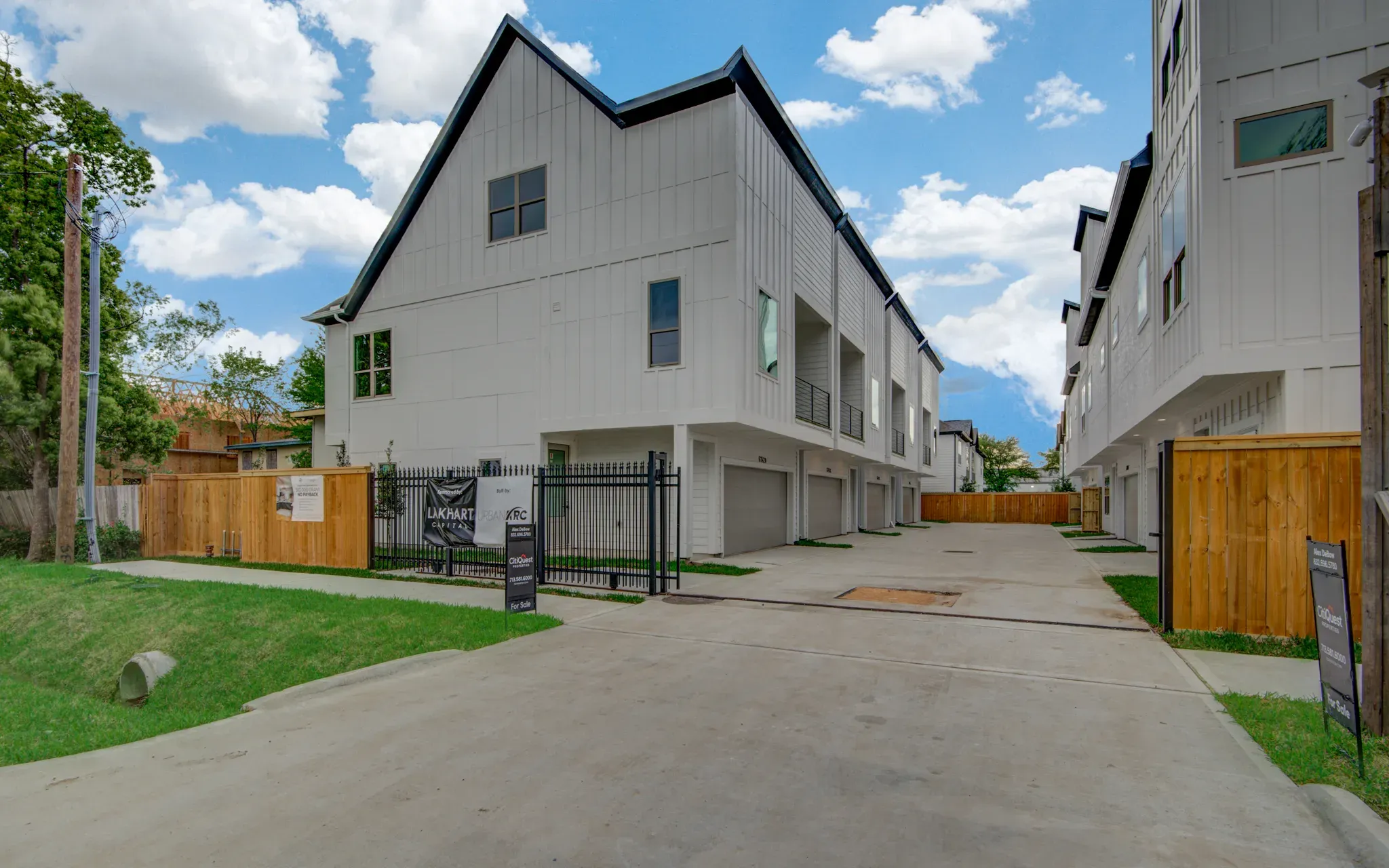 Three-story white townhomes along the private drive at Peerless Court