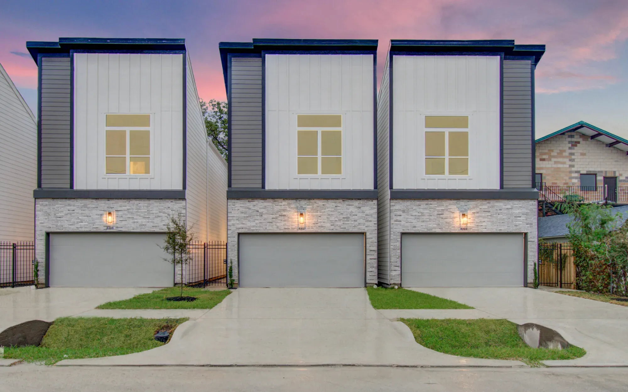 Three modern townhomes at Cadillac Place at dusk